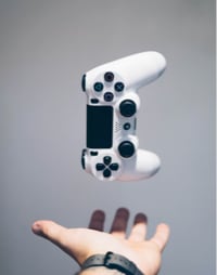 A hand and a video game controller cover image